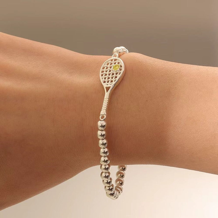 Lovematch Silver bead stretch bracelet with tennis racquet and ball design on a model