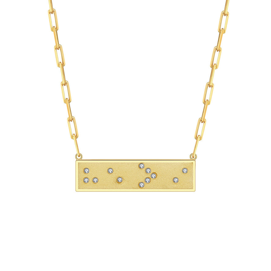Gold necklace with a horizontal rectangular pendant featuring small crystals in Braille spelling 'He > i' He is Greater Than I on a white background