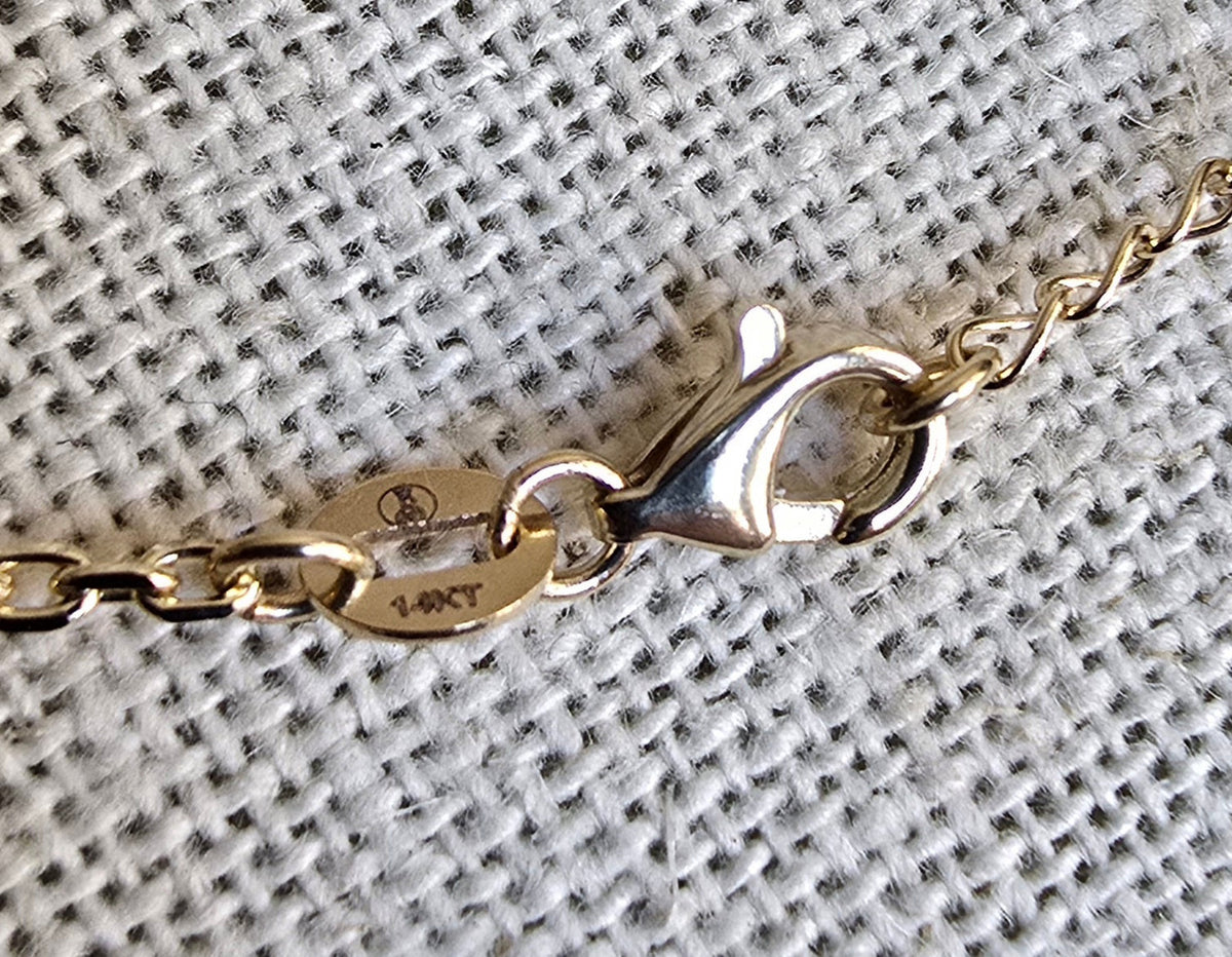 Gold bracelet with clasp on a textured gray background