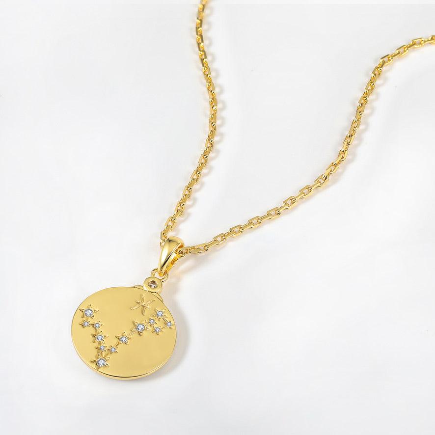 Gold necklace with a Pisces constellation design pendant on a white background