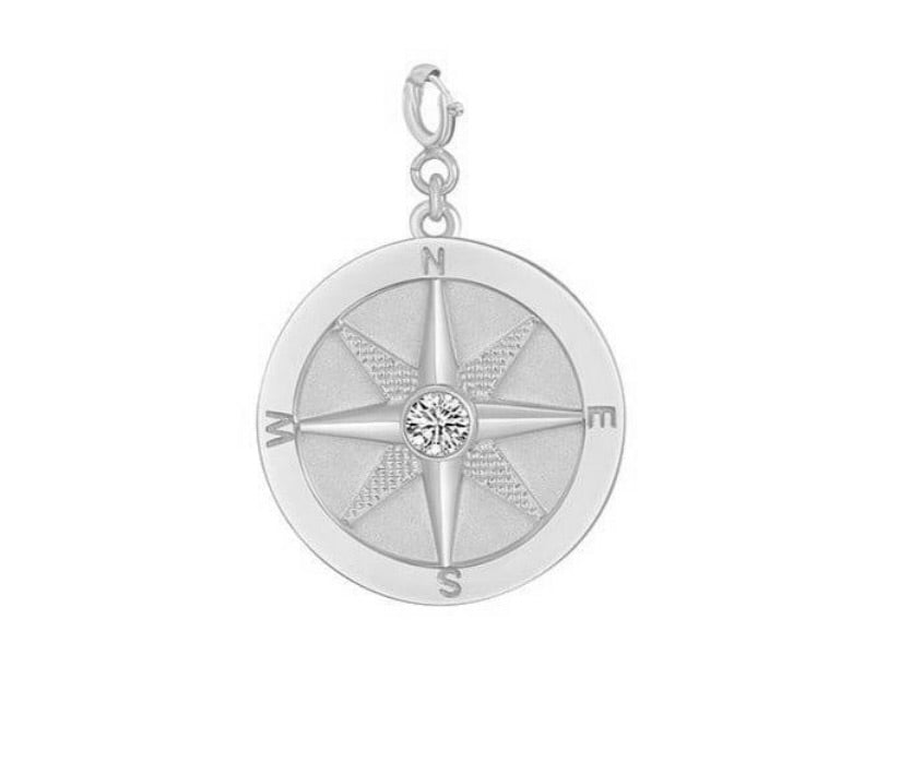 Saints and Saviors Silver compass pendant with a clear gemstone on a white background
