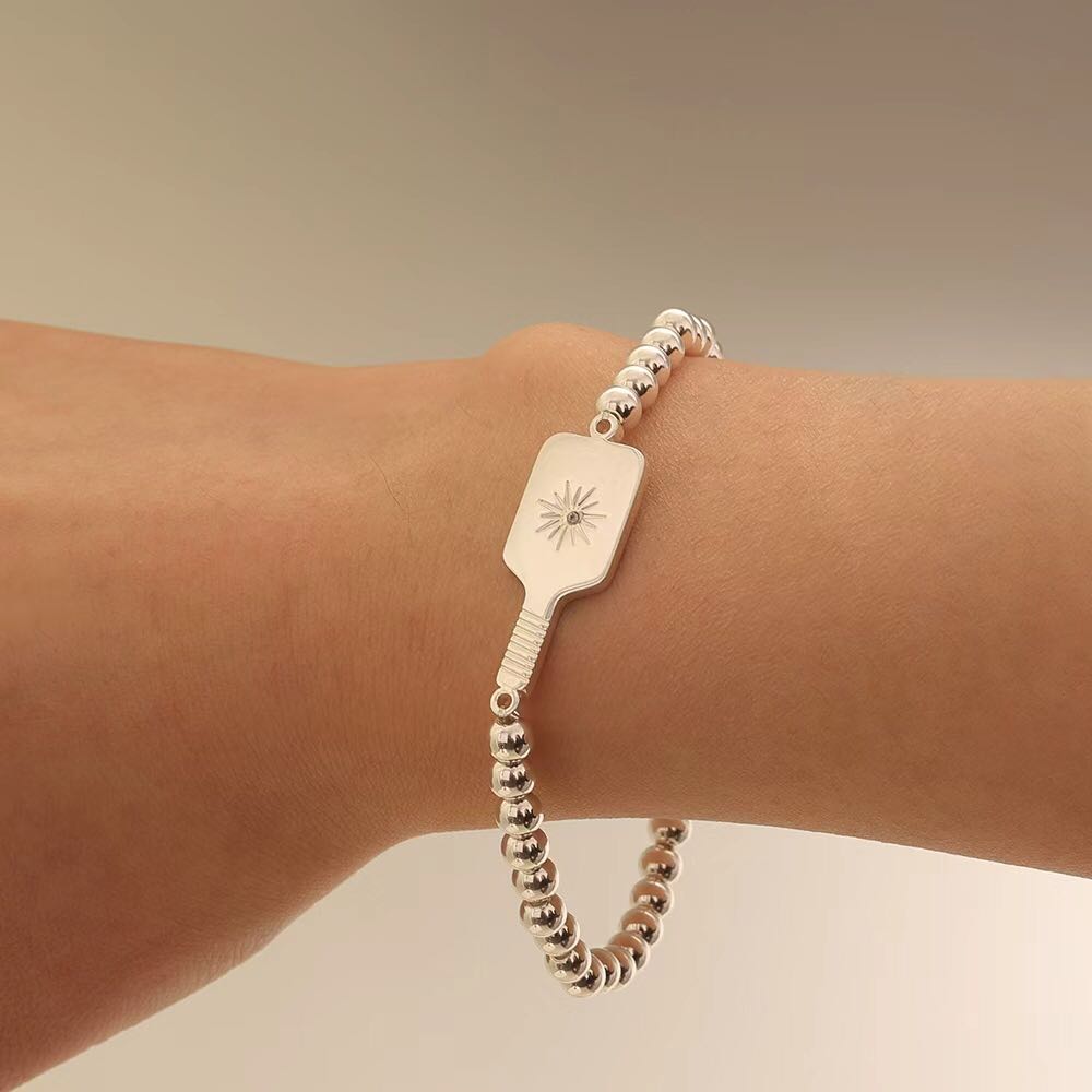 Picklebelle Silver beaded stretch bracelet with pickleball paddle on model