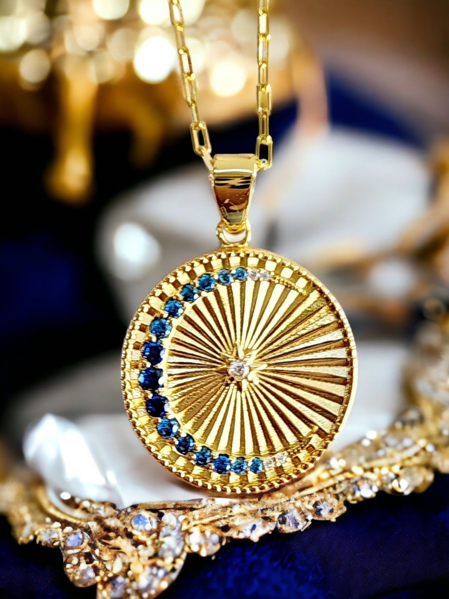 Saints and Saviors Gold 'Over the Moon' necklace with a decorative Moon and Sun pendant featuring ombre blue crystals
