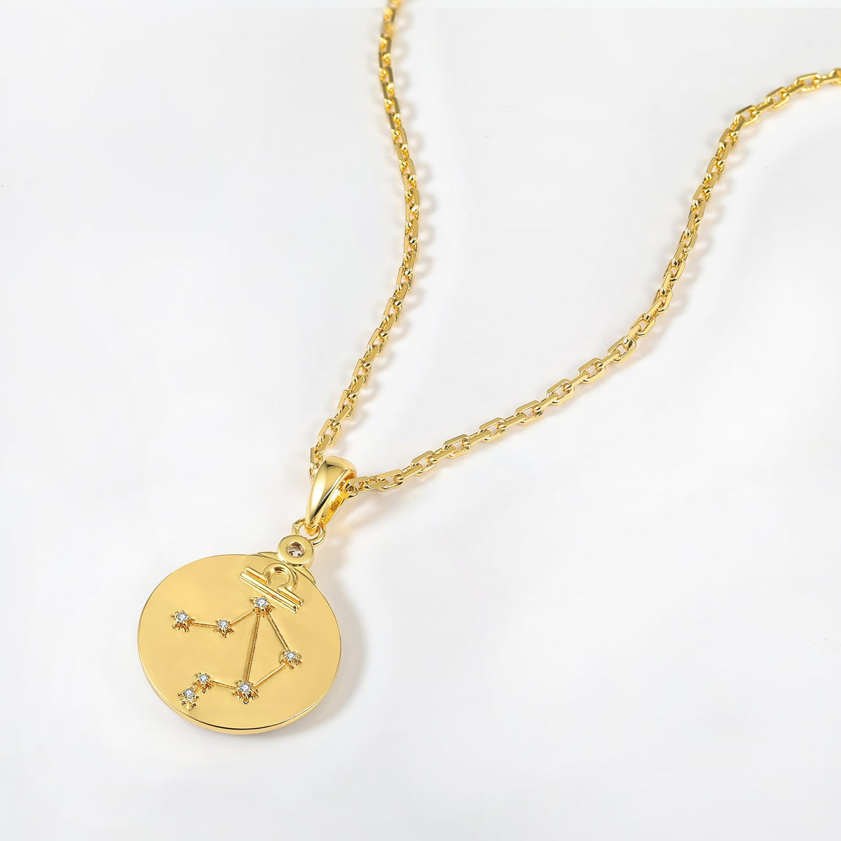 Gold necklace with a zodiac Virgo constellations pendant on a white background