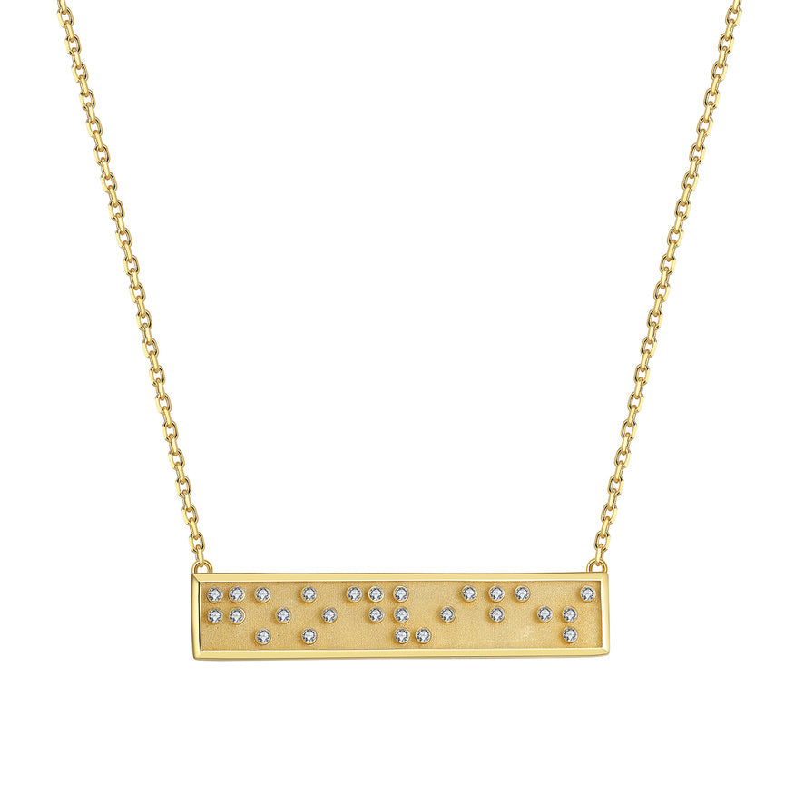 Gold necklace with a bar pendant with Good Vibes in Braille crystals on a white background