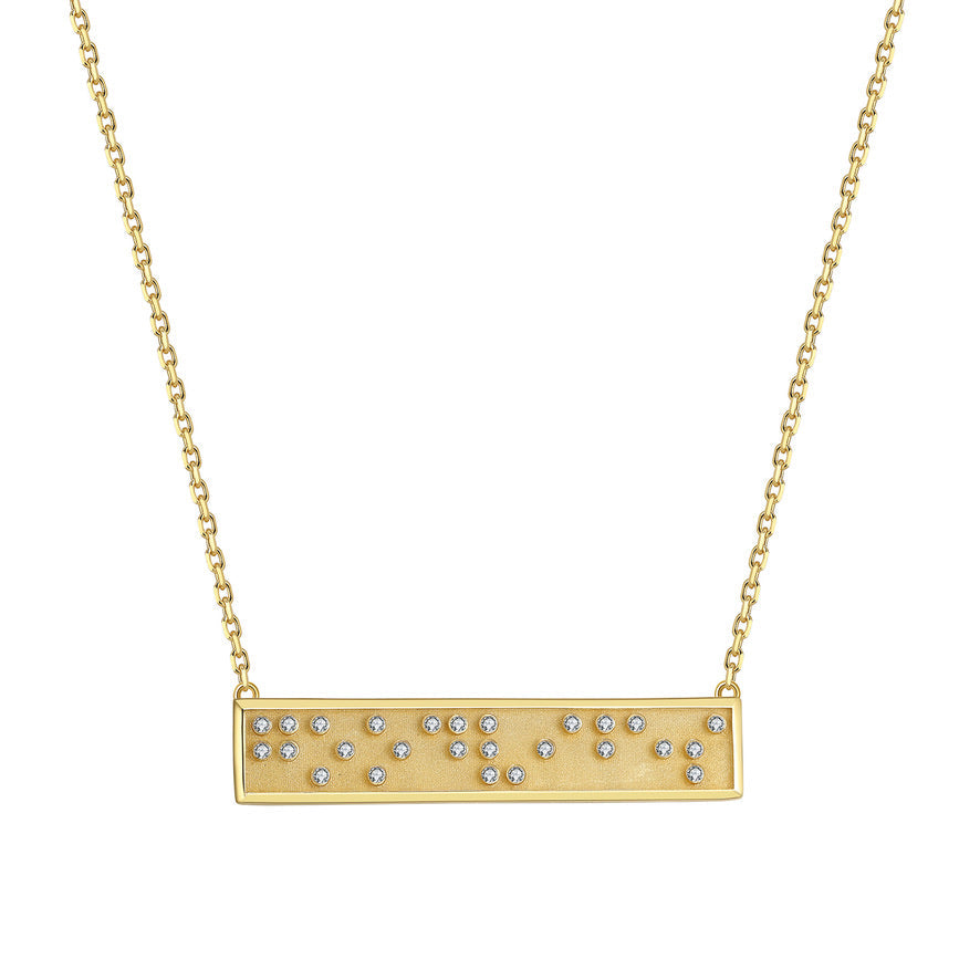 Gold necklace with a bar pendant with Good Vibes in Braille crystals on a white background