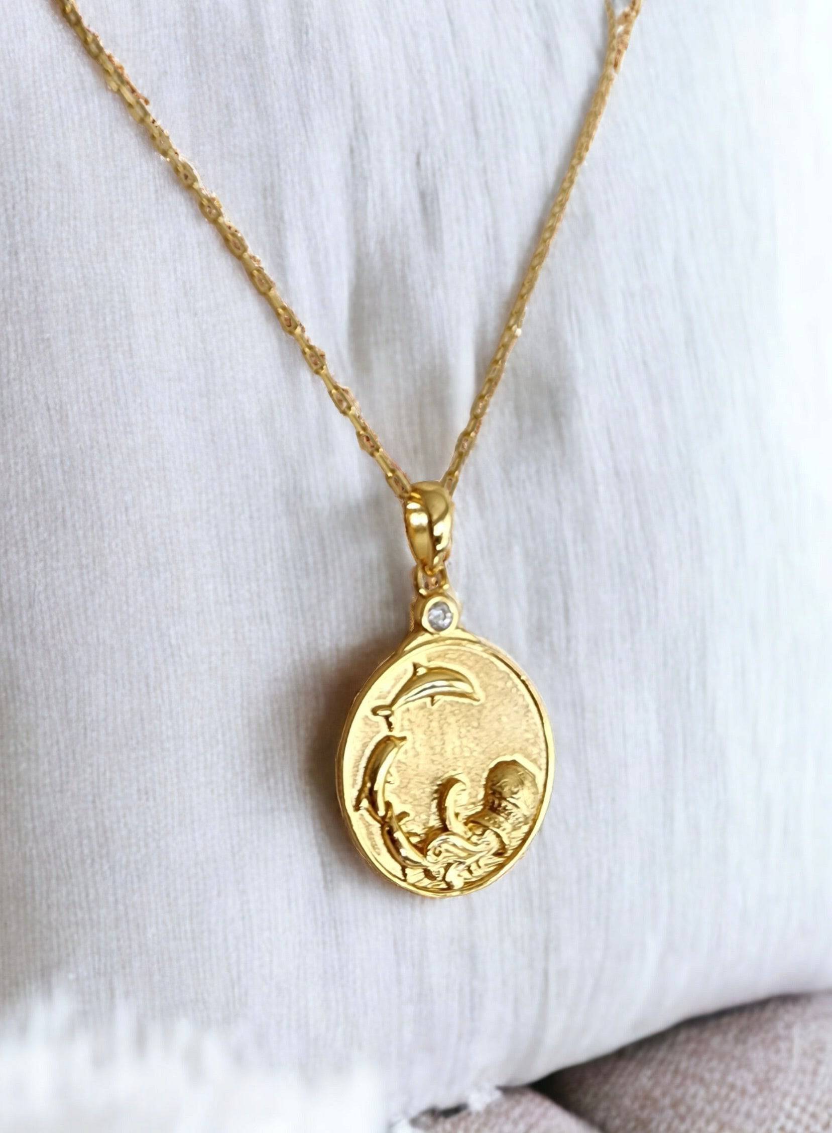 Gold Zodiac Aquarius Medallion Necklace depicting dolphins leaping in water from an urn