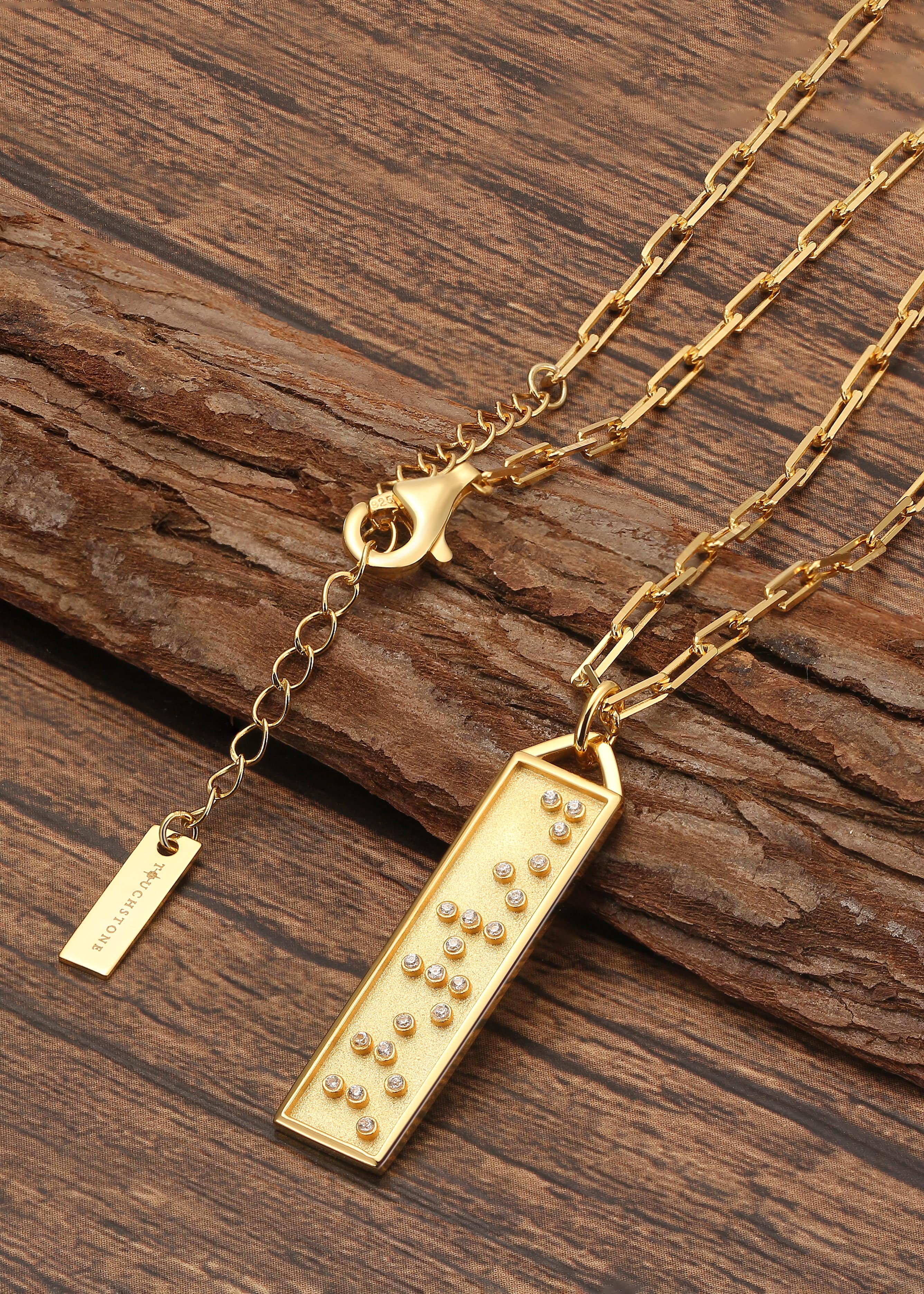 Touchstone Fearless Bar Necklace Gold Braille Crystals on wooden surface