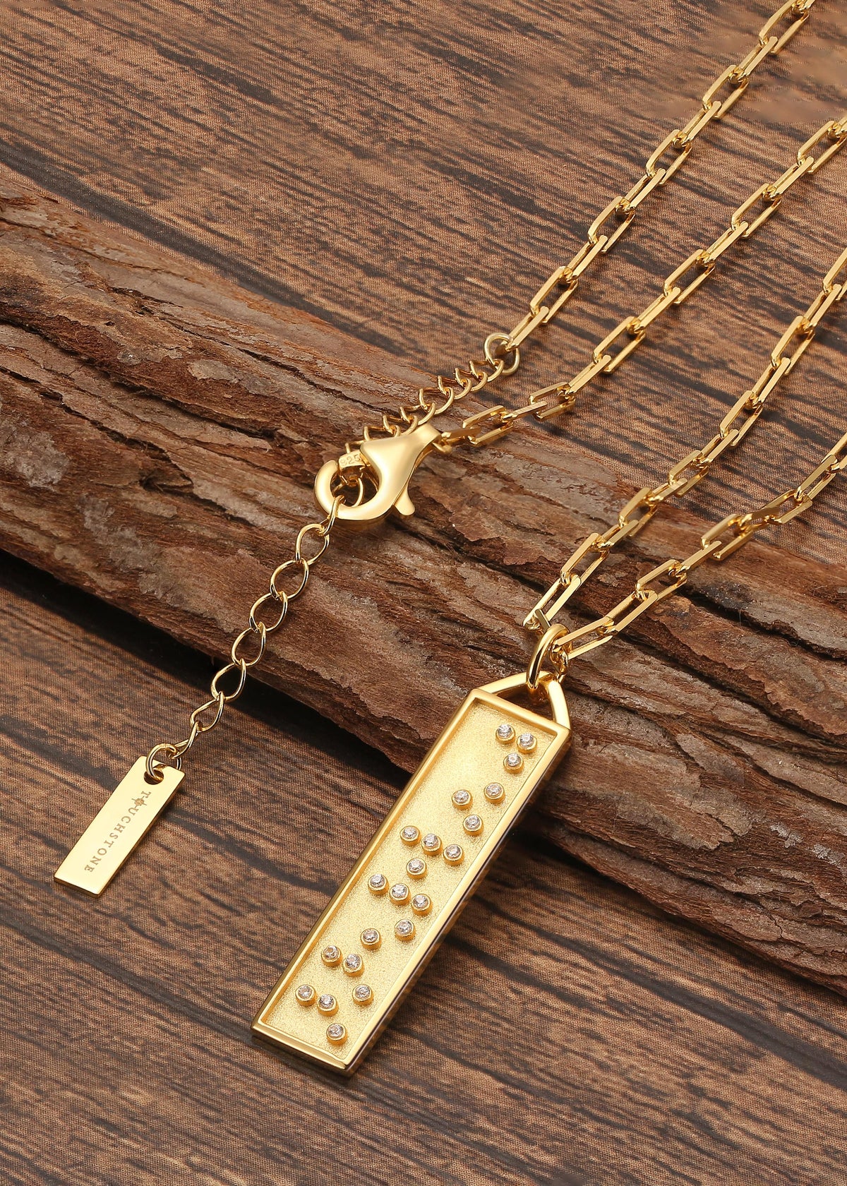Touchstone Fearless Bar Necklace Gold Braille Crystals on wooden surface