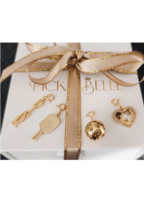 Pickleball Heart Charm Paddle Charm DINK Charm and Ball Charm in Gold all displayed on white Picklebelle gift box