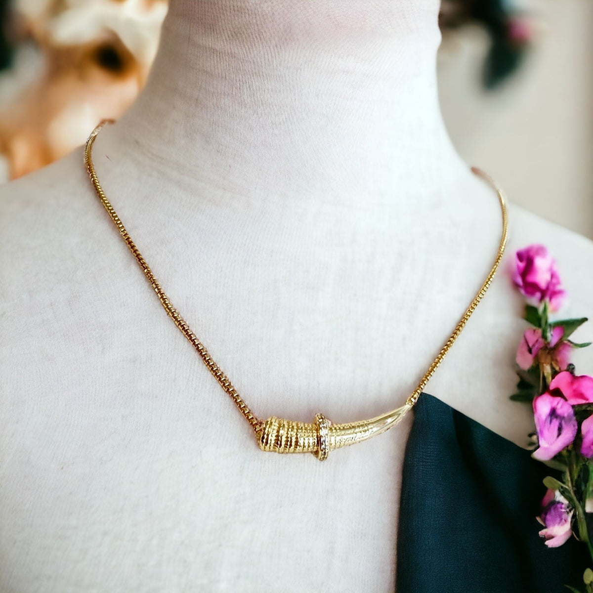 Gold horizontal horn necklace on a mannequin