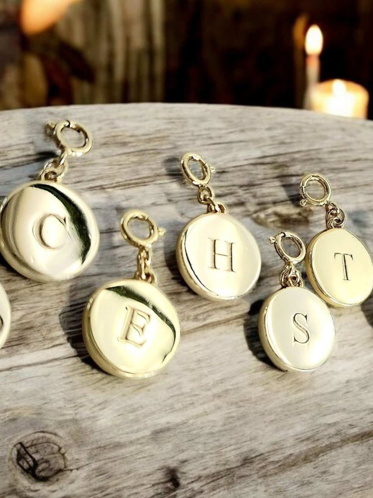 Saints and Saviors Dainty Fancy Initial Clip on Charm letters C E H and T on a wooden surface