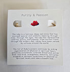 Pair of gold earrings on a card with 'Purity & Passion' text and ruby illustration.