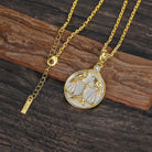 Gold and silver necklace with a zodiac Libra pendant depicting the classic Scale with two Ravens on a wooden surface