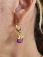 Gold earring with ruby birthstone  nugget worn on an ear