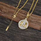 Gold and silver necklace with a Zodiac Gemini pendant featuring two leopards on a wooden surface