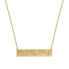Gold necklace with a bar pendant with Good Vibes in Braille crystals on a white background