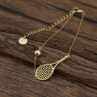 LoveMatch Tennis Ace Racquet and Ball on Gold Chain Bracelet on wood surface