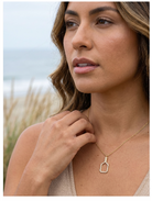 Woman wearing a gold pickleball paddle necklace with diamonds outdoors