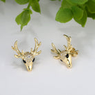Gold deer head earrings with antlers gemstones on a light background.